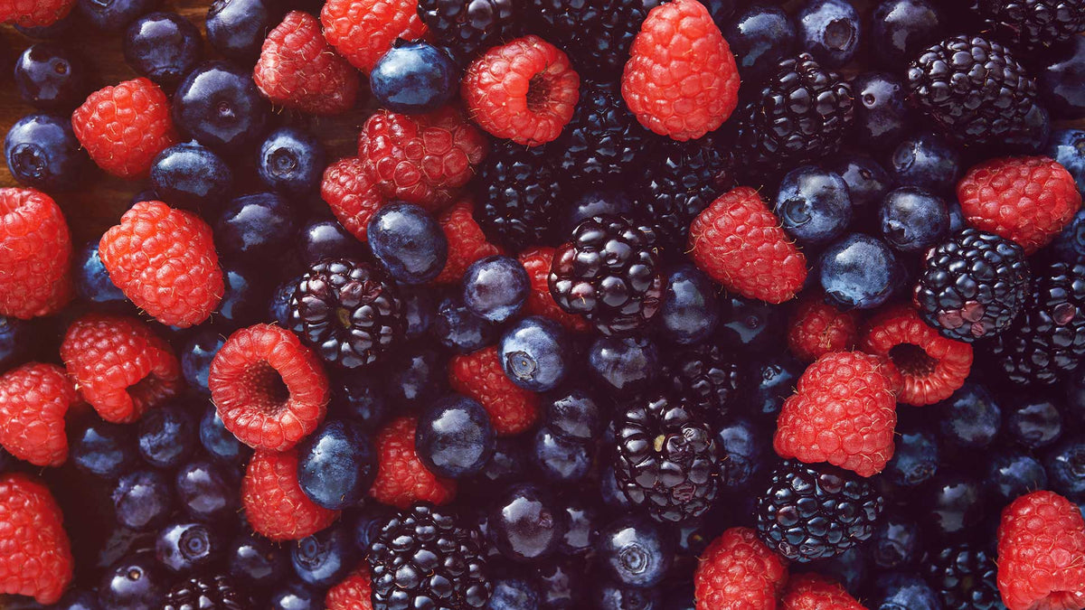 Nahaufnahme von roten Himbeeren und dunklen Beeren wie Heidelbeeren und Brombeeren