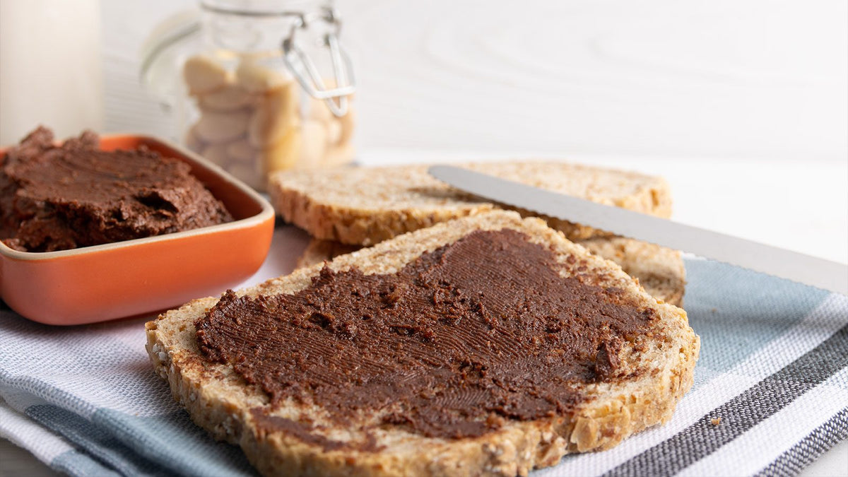 Ein beschmierte Brotscheibe mit veganem Schoko-Proteinaufstrich