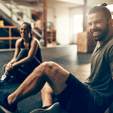Eine junge Frau und ein Mann in Sportkleidung in einem Fitnesscenter