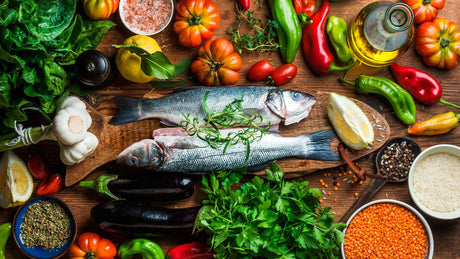 Zwei Fische, Obst und Gemüse auf einem Holzhintergrund schön hergerichtet