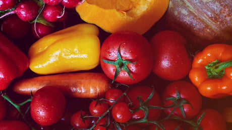 Nahaufnahme von gelber Paprika, roten Tomaten, Radieschen, Karotten etc.