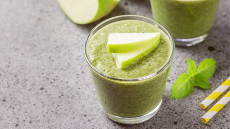 Ein Smoothieglas mit Matcha, Apfel, Spinat und Ingwer.
