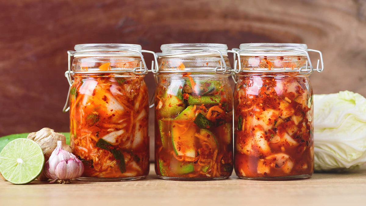 Drei Einmachgläser mit Kimchi, fermentiertes Chinakohl und anderes Gemüse