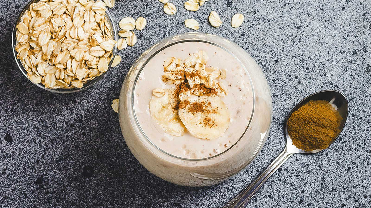 Ein Glas mit Maca-Smoothie und Haferflocken
