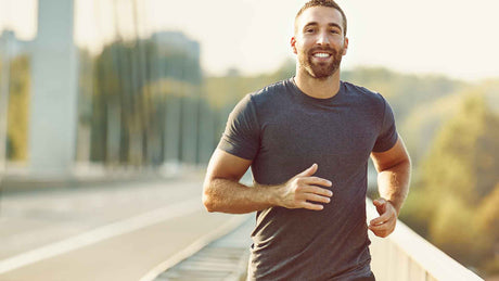 Ein junger Mann mit Bart beim Joggen in der Stadt.