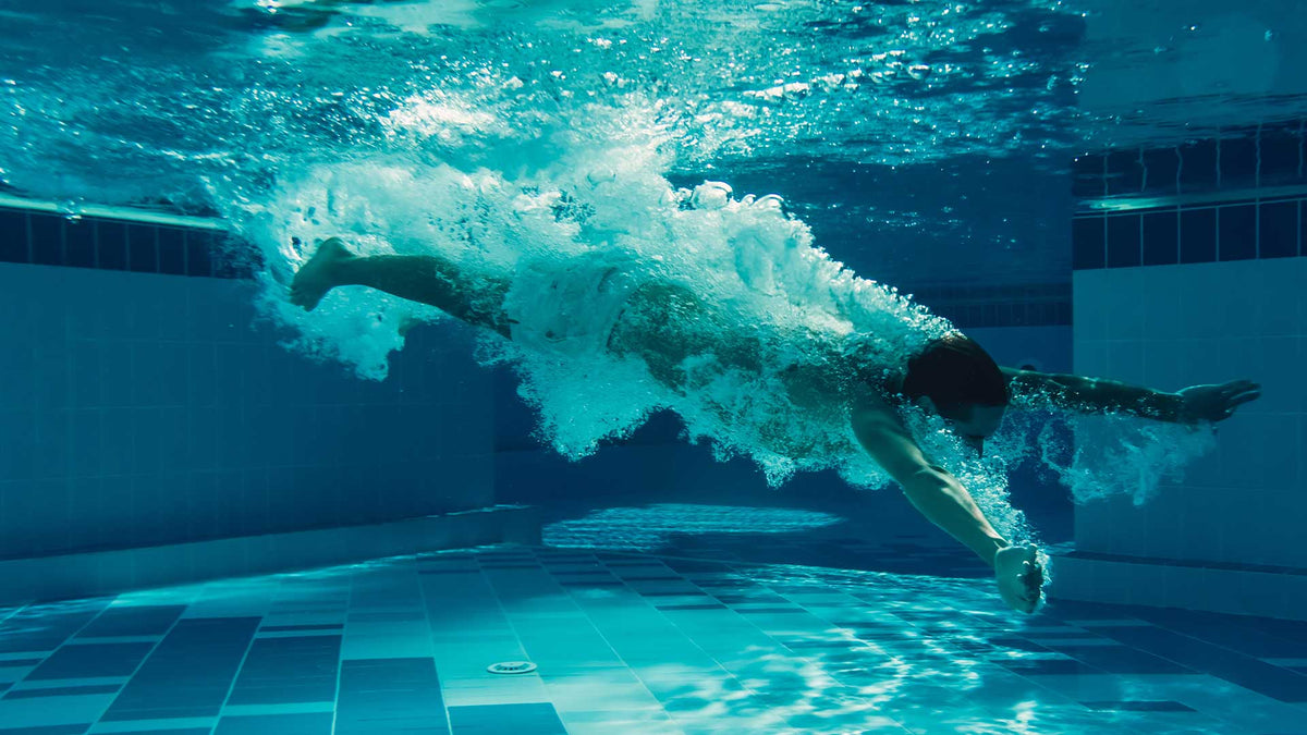 Ein junger Mann schwimmt unter Wasser