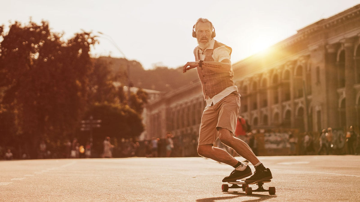 Ein älterer Skater mit weißem Bart fährt souverän auf dem Skateboard
