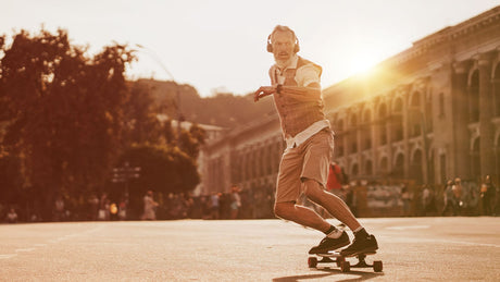 Ein älterer Skater mit weißem Bart fährt souverän auf dem Skateboard