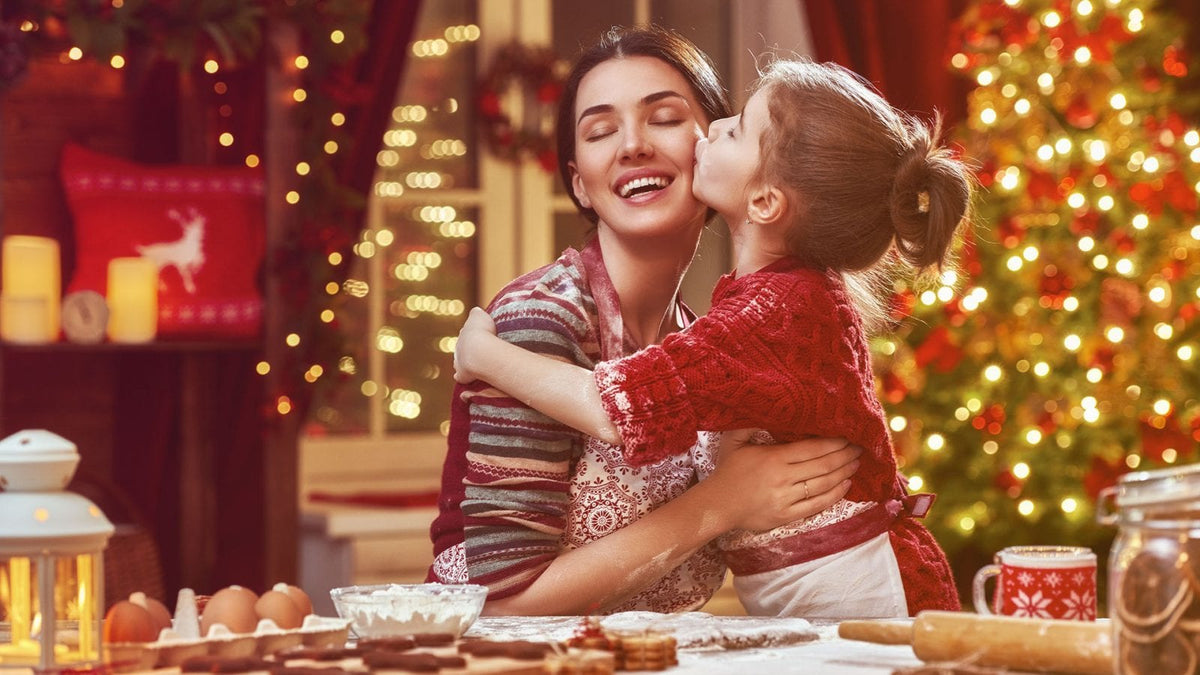 Eine kleine Tochter küsst die Mutter zu Weihnachten.