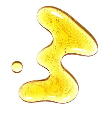 Goldgelber Tropfen und Ölpfütze auf weißem Hintergrund.