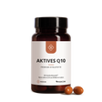 Eine braune Flasche mit der Aufschrift "Median Aktives Q10" von Medicom, die hochwertiges Kaneka Ubiquinol enthält, wird mit drei braunen Kapseln daneben auf einem weißen Hintergrund gezeigt.