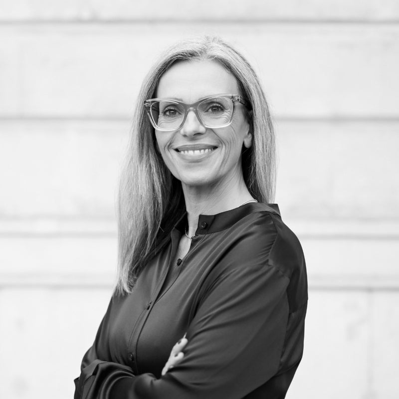 Ana Lorena Gómez ist Managing Director der Medicom. Ihre langjährige Expertise und Wissen über Ernährung, Nahrungsergänzung, Prävention und Healthy Longevity teilt sie auch Medicom Blog als Blogautorin und Interviewerin. Schwarz-Weiß-Bild. Ana trägt eine Bluse und eine Brille. Sie lächelt in die Kamera.
