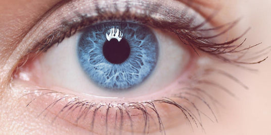 Nahaufnahme eines blauen menschlichen Auges mit langen Wimpern und detaillierten Irismustern.