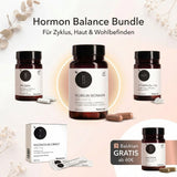 Das Paket Medicom Balanced Hormones | Woman Health mit vier Gläsern für Nahrungsergänzungsmittel und einer Magnesiumbox wird auf einem hellen Hintergrund mit Blumen dargestellt.