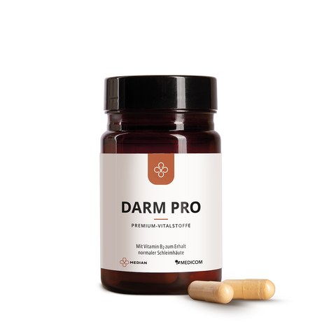Eine braune Dose mit der Aufschrift Median Darm Pro von Medicom mit zwei beigen Kapseln, die Bakterienkulturen und Vitamin B2 enthalten, ist daneben auf einem weißen Hintergrund abgebildet.