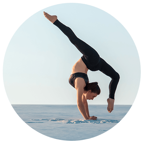Ein junge, gelenkige Frau macht eine Yogahaltung für Fortgeschrittene