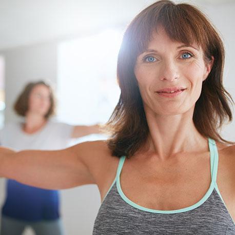 Eine Frau mittleren Alters macht eine Dehnübung