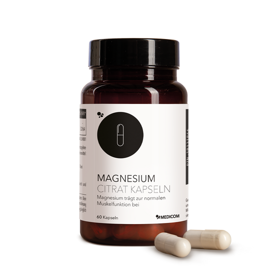 Eine Flasche Magnesium Citrat Kapseln mit zwei Kapseln daneben auf einem weißen Hintergrund.