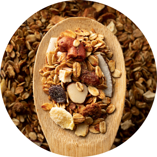 Holzlöffel mit magnesiumhaltigen Lebensmitteln wie Nüsse und Haferflocken