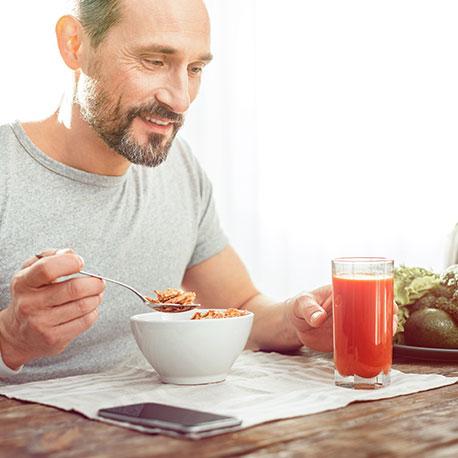 Ein Mann mittleren Alters frühstückt gesund