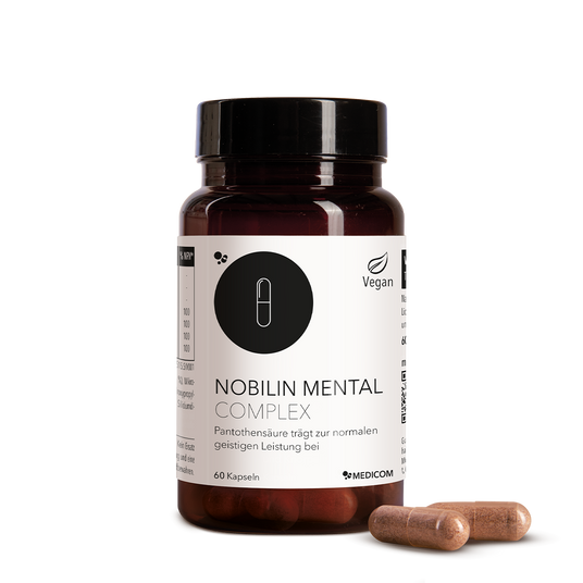 Eine Flasche mit Nobilin Mental Complex Kapseln mit zwei daneben platzierten Kapseln auf weißem Hintergrund.