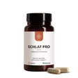 Median Schlaf Pro dark bottle with label and two capsules in front on a white background, formulated to promote faster sleep onset (schnelleres Einschlafen) and enhance sleep quality (Schlafqualität).