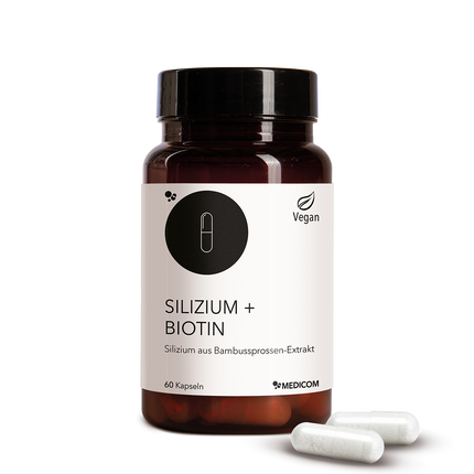 Die Produktdose von Silizium + Biotin in der Vorderansicht und zwei Kapseln vor der Produktdose