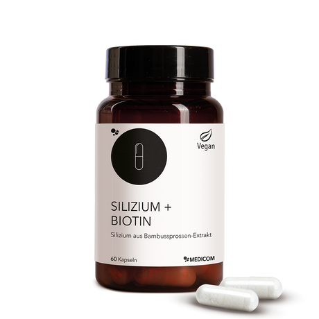 Die Produktdose von Silizium + Biotin in der Vorderansicht und zwei Kapseln vor der Produktdose