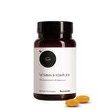 Eine Flasche Medicom Vitamin-B-Komplex mit zwei gelben Kapseln daneben auf weißem Hintergrund – für ein gesundes Nervensystem.