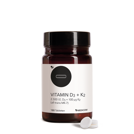 Die Produktdose von Vitamin D3 + K2 Tabletten und drei Tabletten im Vordergrund