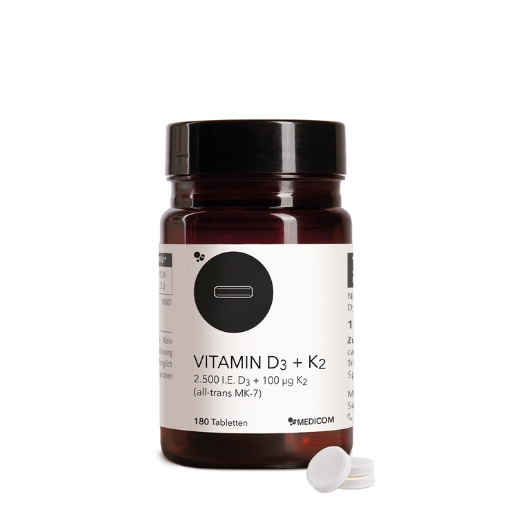 Die Produktdose von Vitamin D3 + K2 Tabletten und drei Tabletten im Vordergrund