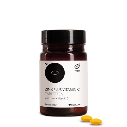 Die Zink Plus Vitamin C Tabletten  in der stilvollen Produktdose von Medicom – Zinkcitrat und Vitamin C. Zwei Tabletten im Vordergrund