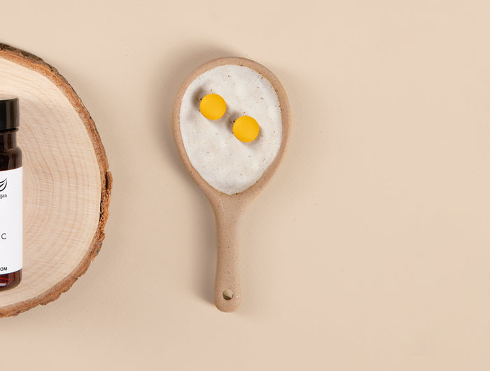 Die Produktdose von Zink plus Vitamin C Tabletten von Medicom und daneben zwei Tabletten auf einem Keramiklöffel