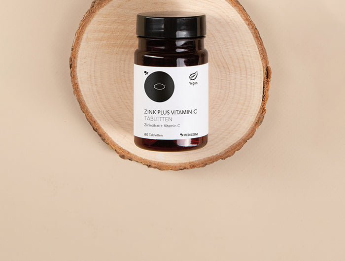 Die Produktdose von Zink Plus Vitamin C Tabletten auf einem Holztablett