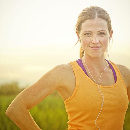 Eine junge sportliche Frau lächelt in die Kamera
