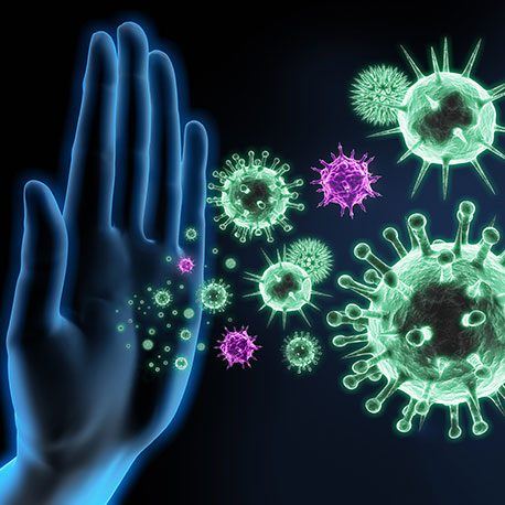 Eine leuchtende Hand blockiert die abgebildeten Viren und steht für den Schutz oder das Immunsystem, das Keime bekämpft.