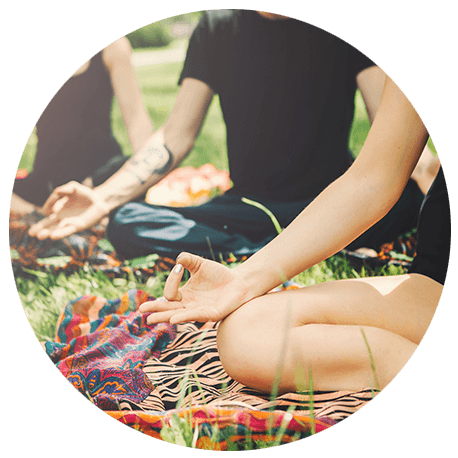 Drei Menschen im Park bei der Meditation