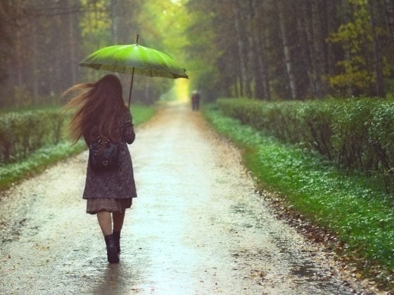 Eine Frau geht bei Regenwetter durch den Wald