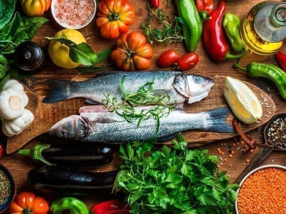 Gesunde Lebensmittel wie Fisch, Obst und Gemüse stilvoll präsentiert