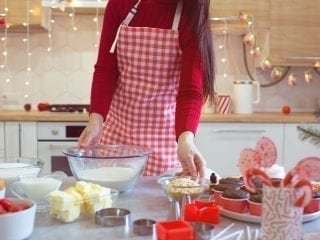 Eine Frau backt in einer Küche mit Weihnachtsdekoration