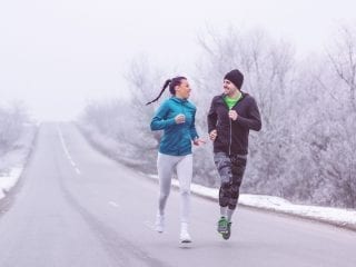 Ein Paar läuft auf einer Straße in einer Winterlandschaft