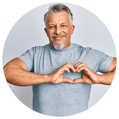 Ein Mann mit Bart formt mit seinen Händen ein Herz auf der Herzhöhe seines Körpers