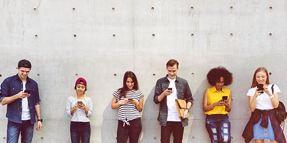 Junge Menschen mit Smartphones erfreuen sich über Medicom 10% Newslettervorteile