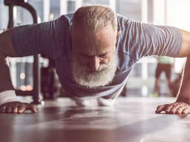 Ein Mann mit Bart im fortgeschrittenen Alter macht eine Kraftübung