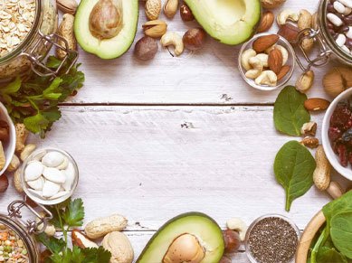Schöne Anordnung von magnesiumhaltigen Lebensmitteln wie Avocado, Nüsse, Chiasamen, grünes Blattgemüse