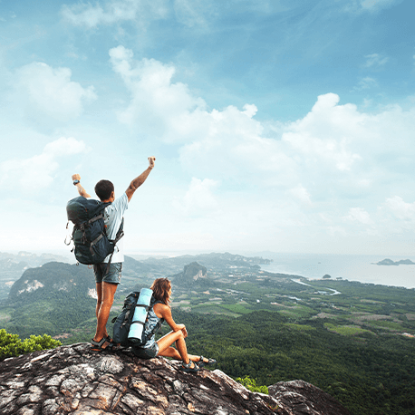 Zwei Bergwanderer stehen auf einem Gipfel und blick auf eine schöne Berglandschaft