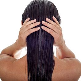 Eine Frau mit nassen Haaren streicht sich die Haare glatt
