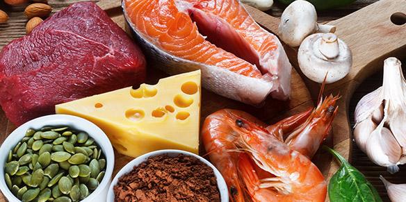 Zinkhaltige Lebensmittel wie Lachs, Käse und Gemüse auf dem Tisch